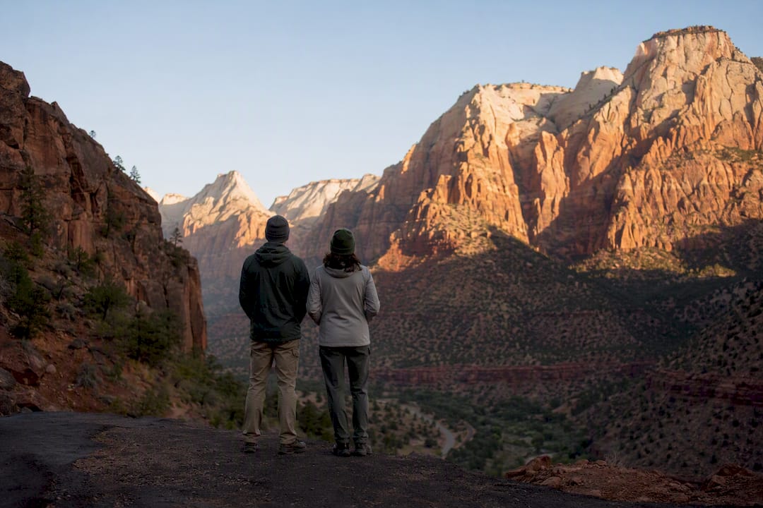 Hikers overlooking Zion canyon at sunrise