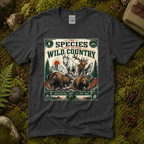 Dark heather grey Wild Country Species tee laid flat on green moss with ferns, river stones and pinecones, showing a vintage badge of a mountain goat, bison, elk, bear and wolf