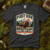 Dark heather grey Guard the Great Plains tee laid flat on green moss with ferns, river stones and a pinecone, showing a vintage badge of a bison on open grassland below snowcapped peaks
