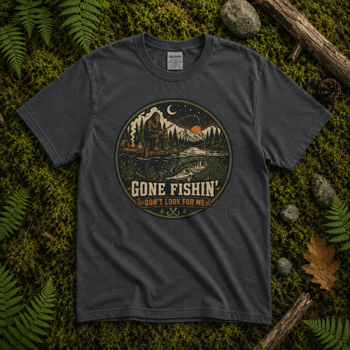 Dark charcoal Gone Fishin' Don't Look For Me tee on green moss, with circular night lake fishing scene badge